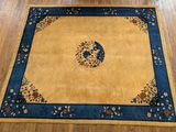 un tapis jaune bordé de bleu posé sur un parquet