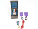 une petite boîte en bois contenant une médaille et deux autres objets