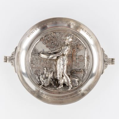 une image représentant une assiette en argent sur laquelle figurent un homme et un chien