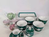 many cups and saucers sitting on a table
