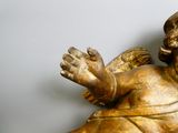 a gold statue of an angel on a white wall