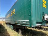 un gros camion vert garé sur le bord de la route