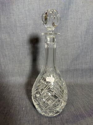 une image représentant une carafe en verre sur fond gris