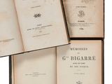 trois vieux livres posés l'un sur l'autre sur une surface blanche