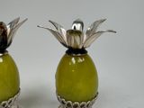 two green vases with flowers on them sitting on a table