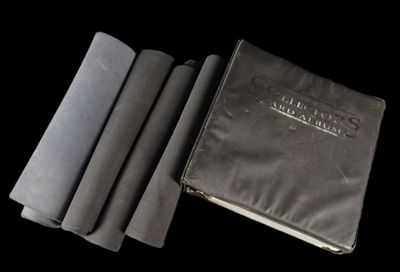 un livre noir à la couverture noire, à côté de quatre livres noirs