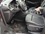 the interior of a red car with black leather seats and a steering wheel