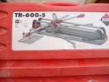 a red box with a picture of a tile cutter on it