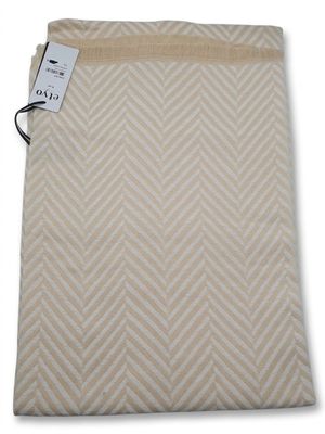 a beige and white blanket with a herring pattern on it