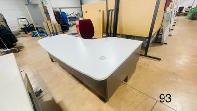 un bureau blanc avec une chaise rouge au milieu de la pièce