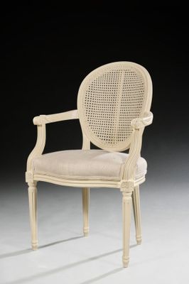 a white chair with a cane back and a beige seat