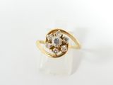 gros plan d'une bague en or avec des diamants sur une surface blanche