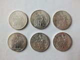 six different types of coins are shown on a white surface