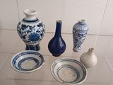 three blue and white vases sitting on a glass shelf