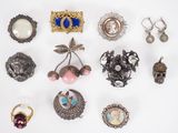 many different types of brooches and jewelry on a white surface