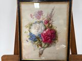 une photo d'un tableau représentant des fleurs posé sur un chevalet