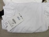 a white shirt with ruffles on the bottom of it
