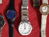 de nombreuses montres différentes posées sur une surface rouge avec un fond rouge