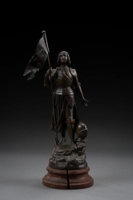 a bronze statue of a woman holding a flag on a pedestal