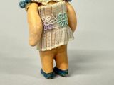 a figurine of a little girl holding a teddy bear