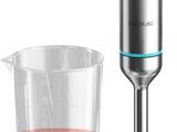 un mixeur posé à côté d'un verre contenant un liquide