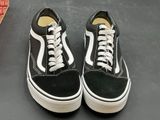 pair of black and white sneakers with white laces on a black surface