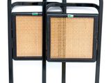 pair of black metal and rattan side tables with rattan seats