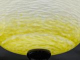a close up view of a lamp with a yellow glass shade