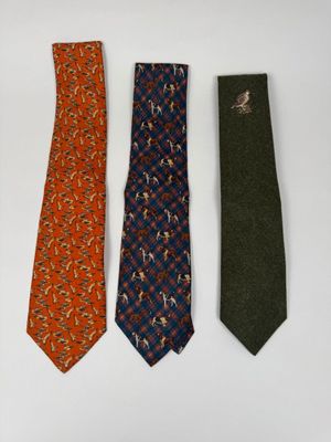 three ties are lined up in a row on a white surface