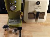 two coffee machines sitting on a table next to each other