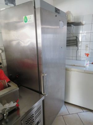 un réfrigérateur en acier inoxydable dans une cuisine carrelée