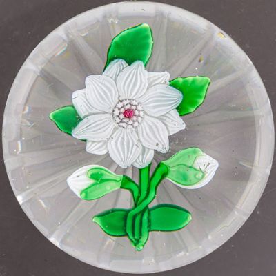une assiette en verre ornée d'une fleur, posée sur une table