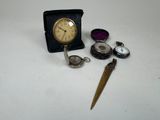 une petite horloge, une montre de poche, un couteau de poche et une montre de poche