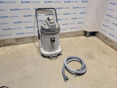 un aspirateur posé sur le sol à côté d'un tuyau
