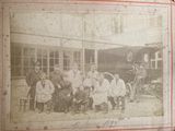 photograph of a group of people posing for a picture in front of a train