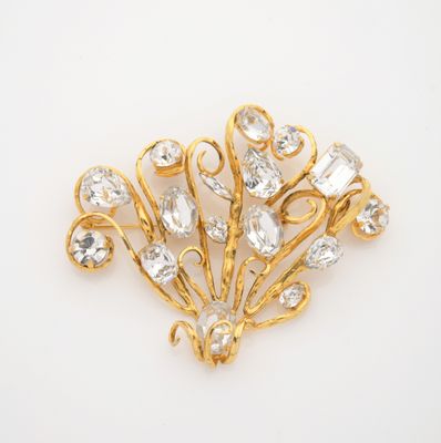 a close up of a gold brooch with clear stones