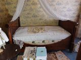un lit surmonté d'un baldaquin, dans une chambre