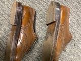 a pair of brown shoes that are on the floor