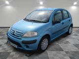 la petite voiture bleue est garée sur un carrelage à carreaux