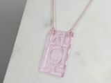 pink acrylic necklace with a geometric design on a gold chain