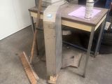 une pile de livres et un balai posés sur une table dans un garage