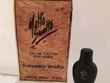 un flacon de parfum posé devant une boîte sur laquelle figure une inscription