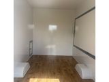an empty room with white walls and wood flooring