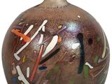 un vase marron orné de motifs colorés sur fond blanc