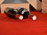 two bottles of wine sitting on a red table cloth