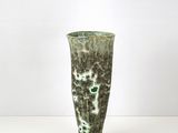 un vase vert posé sur une table blanche
