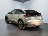 the rear end of a silver car parked in a garage