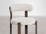 a white chair with wooden legs and a white seat