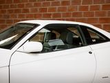 a white car that is parked in front of a brick wall