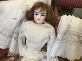 a doll that is laying on the floor next to a pillow